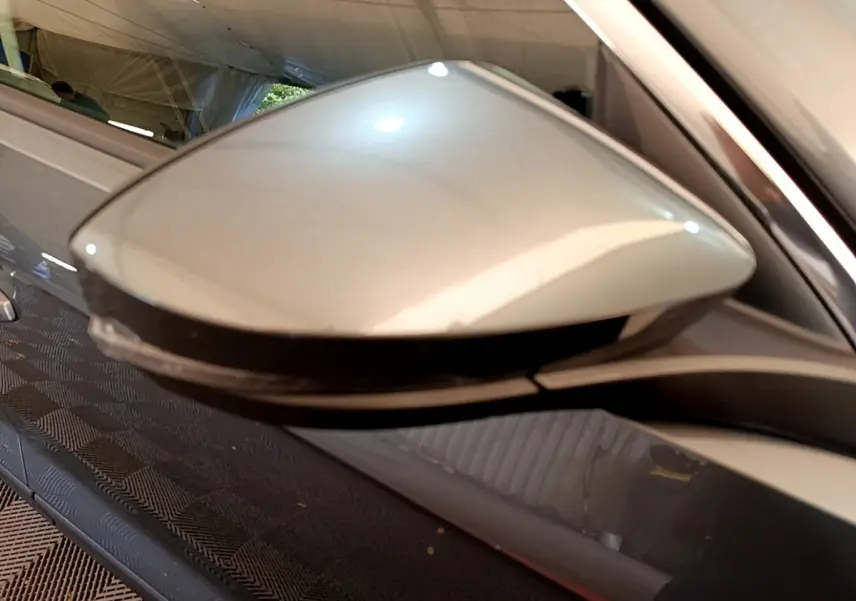 Rétroviseur droit gris foncé du Volkswagen T-Roc 2021, avec clignotant intégré visible en bas.