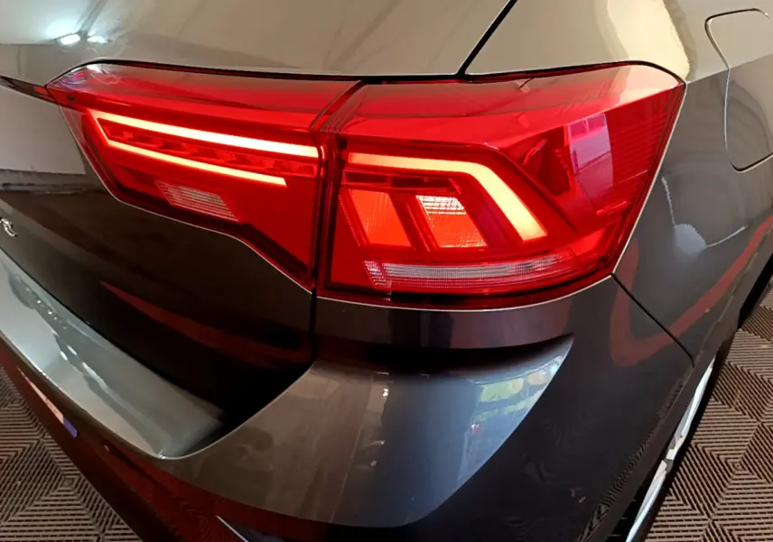 Gros plan sur le feu arrière droit rouge d’un Volkswagen T-Roc gris foncé 2021, finition Lounge Business.