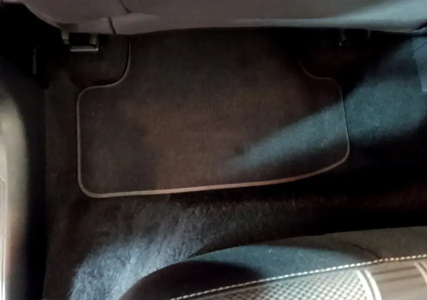 Tapis de sol noir côté passager avant du Volkswagen T-Roc gris foncé 2021, vue rapprochée intérieure.