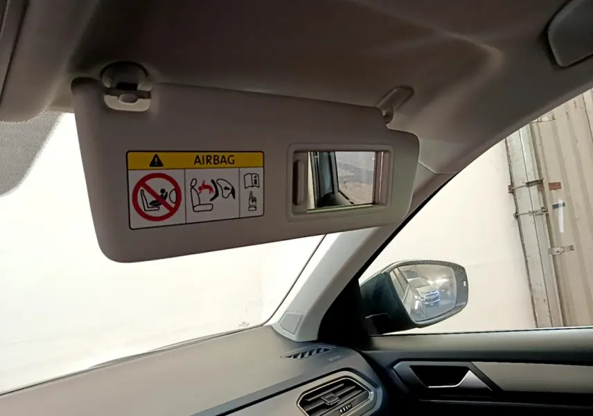 Détail du pare-soleil côté conducteur avec miroir et avertissement airbag, tableau de bord gris foncé Volkswagen T-Roc 2021.