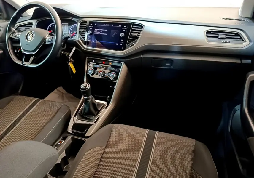 Intérieur du Volkswagen T-Roc 1.0 TSI 110 Lounge Business 2021, vue du poste de conduite avec volant cuir et boîte manuelle.