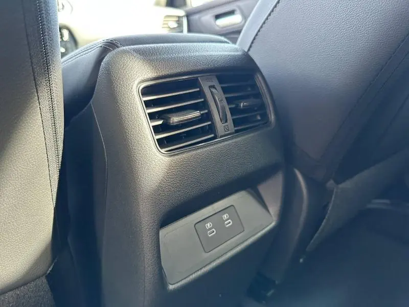 Vue rapprochée de la console arrière noire du Nissan Qashqai Hybrid e-POWER 2025 avec bouches d’aération et ports USB.