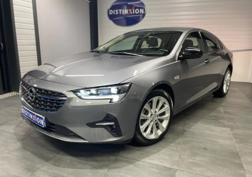 Opel Insignia Grand Sport gris clair vue 3/4 avant avec jantes alliage 17 pouces et coques de rétroviseurs noir laqué.