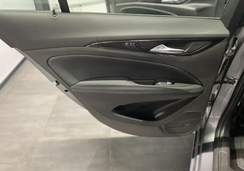 Gros plan sur la porte avant gauche gris clair de l'Opel Insignia Grand Sport avec garniture noire et insert décoratif.