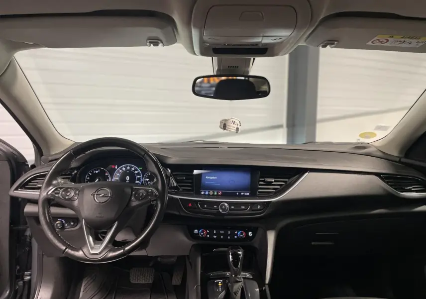 Intérieur noir de l’Opel Insignia Grand Sport 2021, vue frontale du tableau de bord avec écran tactile central et volant cuir multifonctions.