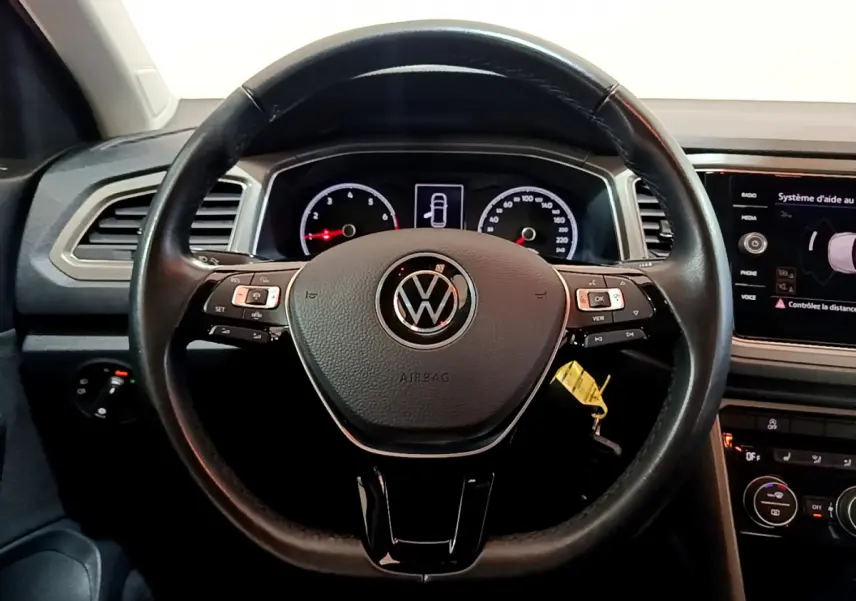 Vue frontale du volant cuir noir Volkswagen T-Roc 1.0 TSI 110 Lounge avec tableau de bord et écran tactile.