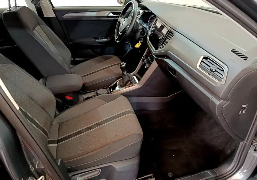 Vue intérieure côté passager du Volkswagen T-Roc 1.0 TSI 110 Lounge 2021 avec sièges tissu gris et tableau de bord moderne.