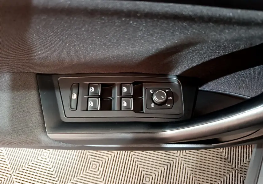 Gros plan sur les commandes des vitres et rétroviseurs côté conducteur d'un Volkswagen T-Roc gris foncé 2021.