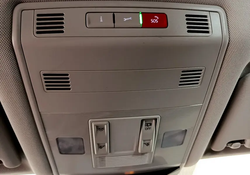 Vue en gros plan du panneau de commande de toit gris clair avec bouton SOS illuminé dans un Volkswagen T-Roc 2021.