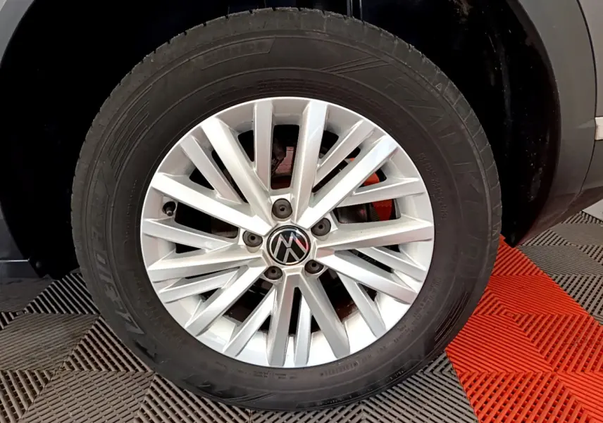 Gros plan sur la roue avant droite avec jante argentée du Volkswagen T-Roc gris foncé 2021.