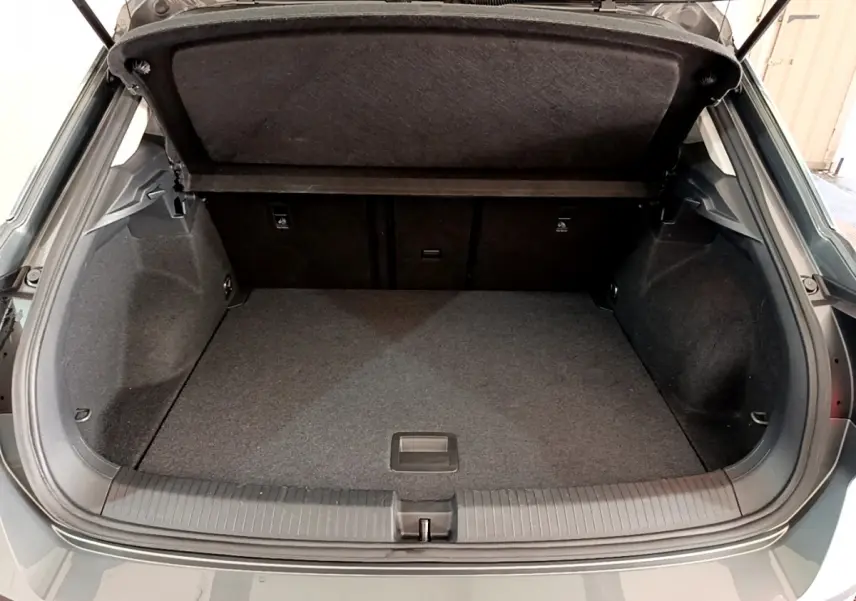 Coffre ouvert vu de l'arrière d'un Volkswagen T-Roc gris foncé, espace de chargement propre et spacieux.