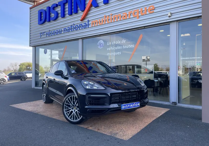 Vue 3/4 avant gauche d’un Porsche Cayenne Coupé E-Hybrid noir, avec jantes alu 22 pouces et calandre sportive.
