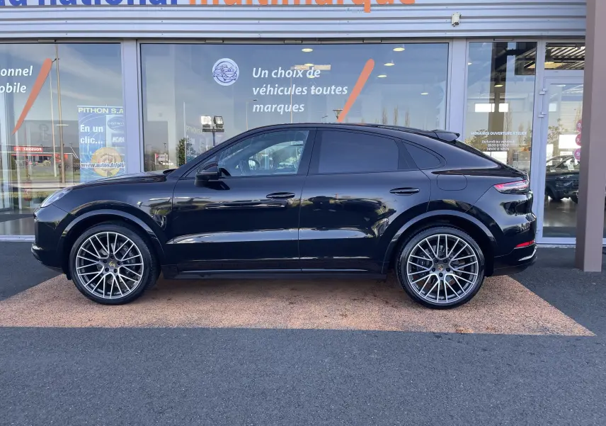 Vue latérale droite d'un Porsche Cayenne Coupé E-Hybrid noir 2021 avec jantes alu 22 pouces et toit panoramique.