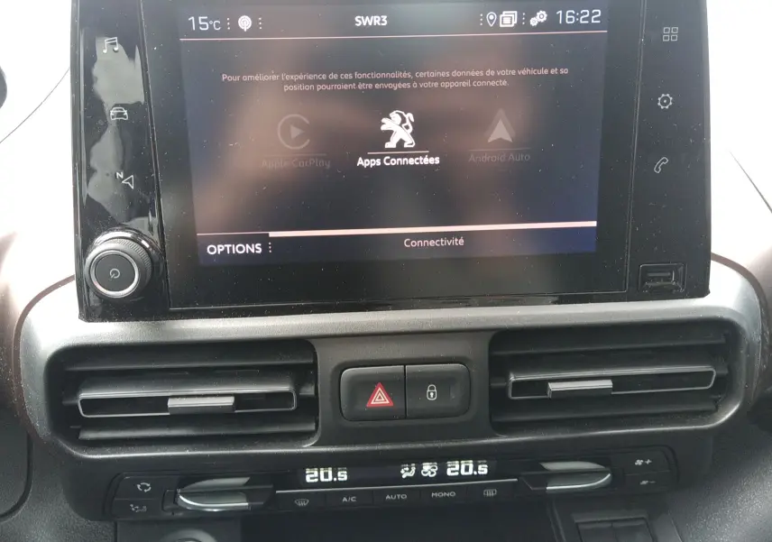Vue rapprochée de l’écran tactile et de la console centrale du Peugeot Rifter 2022 gris platinium avec climatisation digitale.