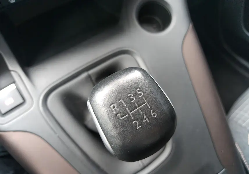 Gros plan sur le levier de vitesses manuel noir du Peugeot Rifter 1.5 BlueHDI 130ch GT, intérieur gris et brun.