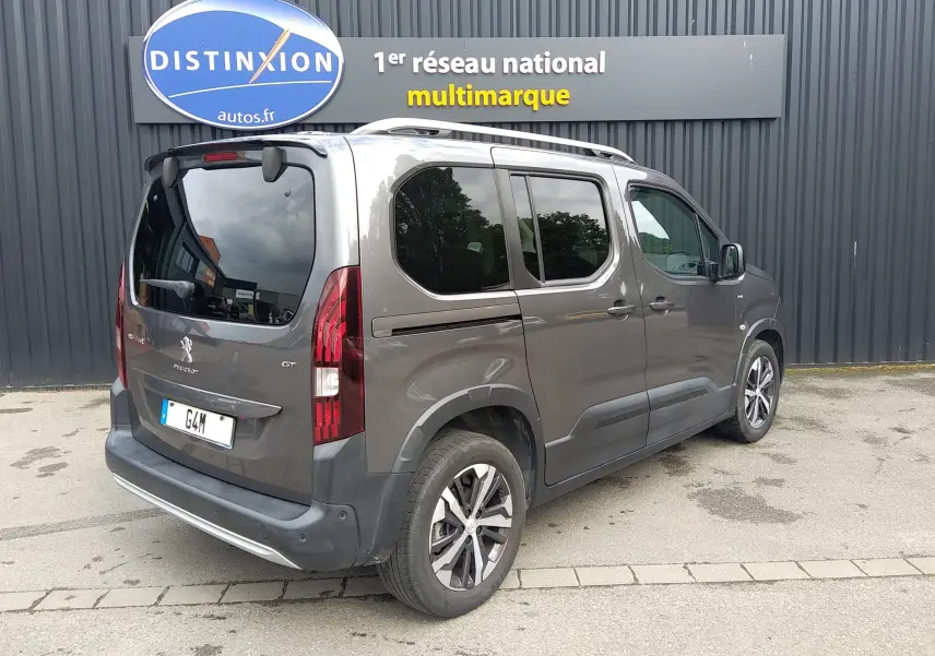Vue 3/4 arrière droite d’un Peugeot Rifter GT 1.5 BlueHDI gris platinium avec vitres teintées et jantes alliage.