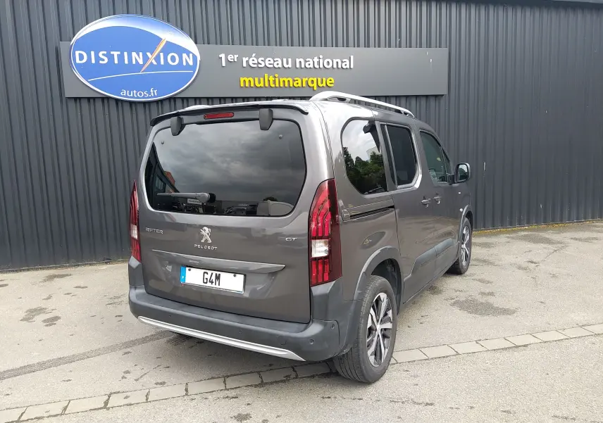 Vue 3/4 arrière droite du Peugeot Rifter gris platinium 2022, avec feux arrière verticaux et vitres teintées.