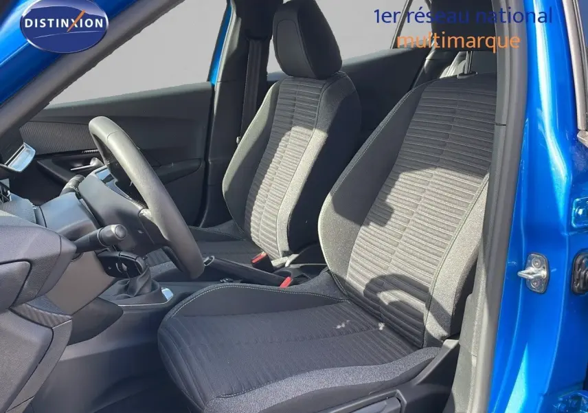 Intérieur avant du Peugeot 2008 bleu Vertigo, montrant les sièges tissu gris et la boîte manuelle côté gauche.