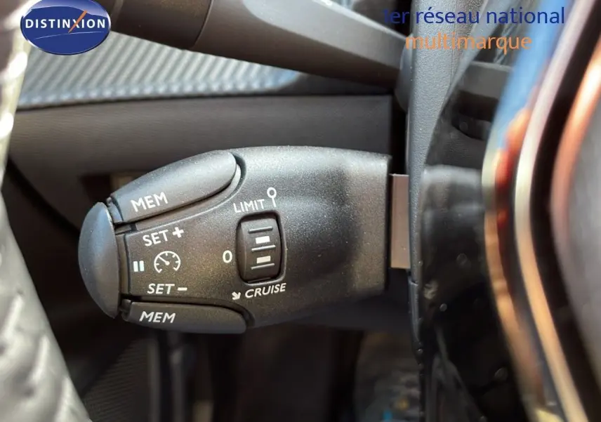 Commande de régulateur de vitesse sur le côté gauche du volant d'un Peugeot 2008 2024, intérieur noir.