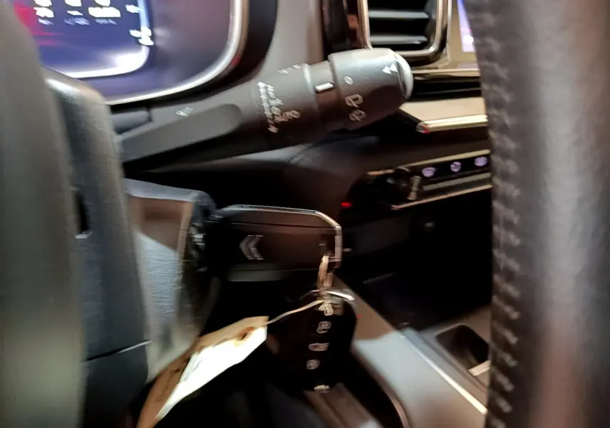 Gros plan sur la clé dans le contacteur d'une Citroën C5 Aircross 2020, tableau de bord et volant en cuir visibles.