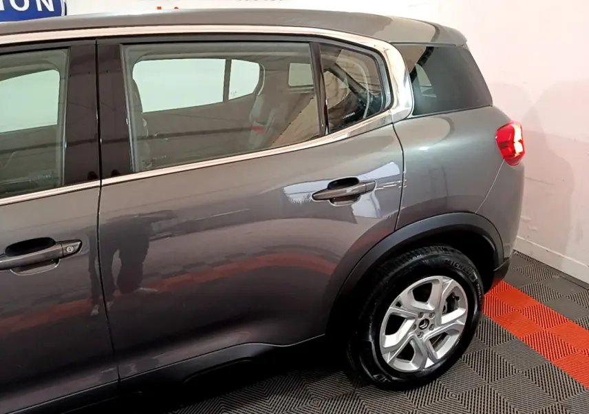 Vue latérale côté droit du Citroën C5 Aircross gris foncé avec jantes alliage 17 pouces et vitres surteintées.