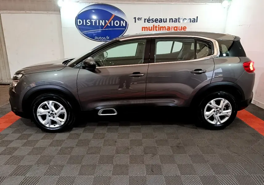 Profil côté gauche d'un Citroën C5 Aircross gris foncé 2020 avec jantes alliage et contours chromés visibles.