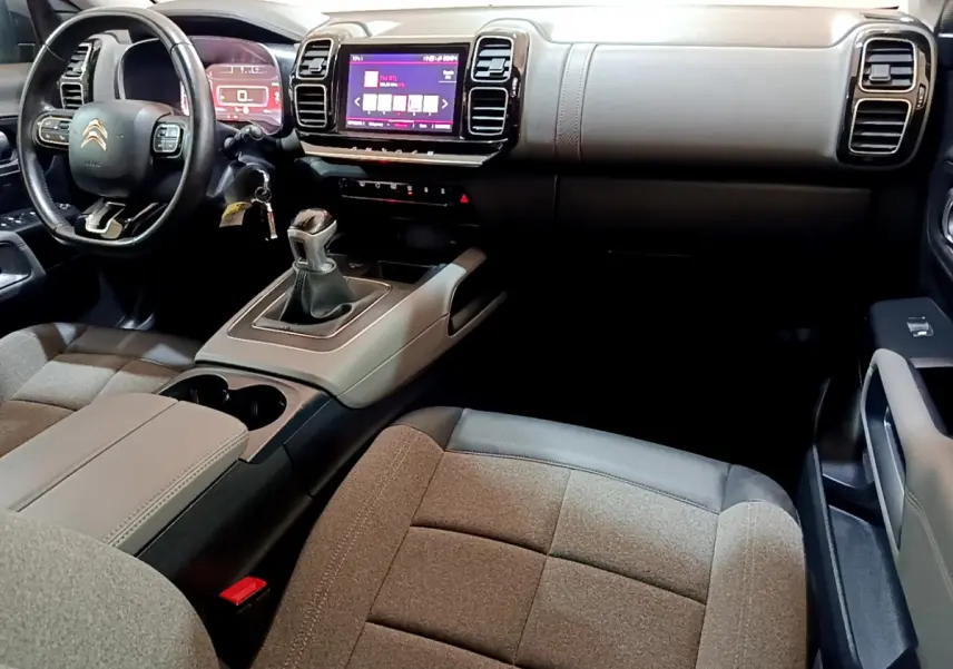 Intérieur du Citroën C5 Aircross 2020 avec tableau de bord noir, écran tactile et sièges tissu gris côté passager.