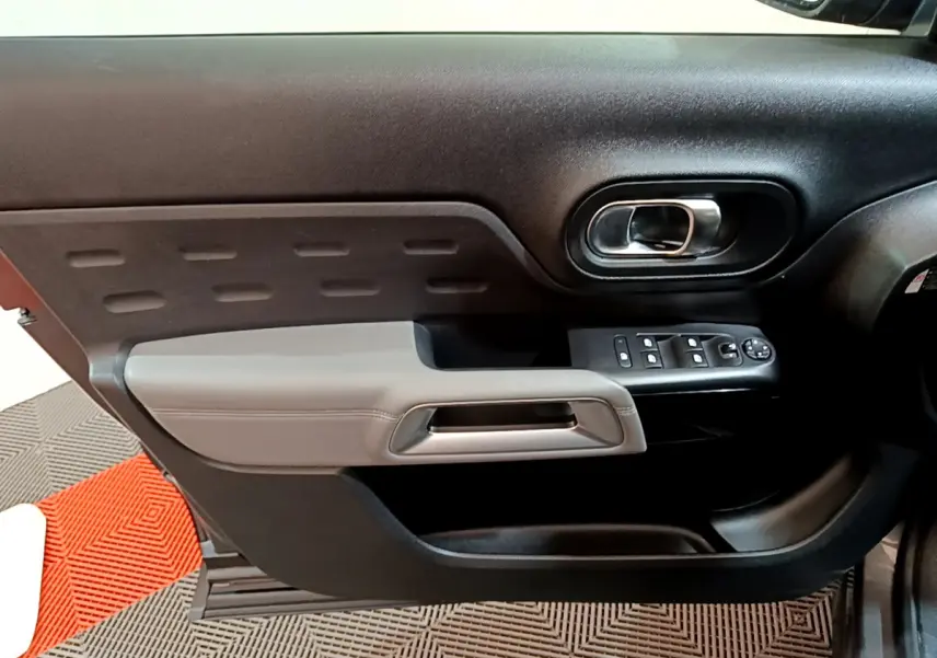 Gros plan sur la porte côté gauche du Citroën C5 Aircross 2020 gris foncé avec commandes de vitres et poignée grise.