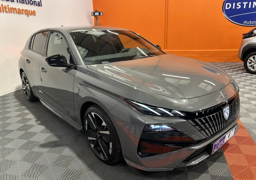 Peugeot 308 gris Selenium vue 3/4 avant droit, avec calandre noire et jantes alliage noires brillantes.