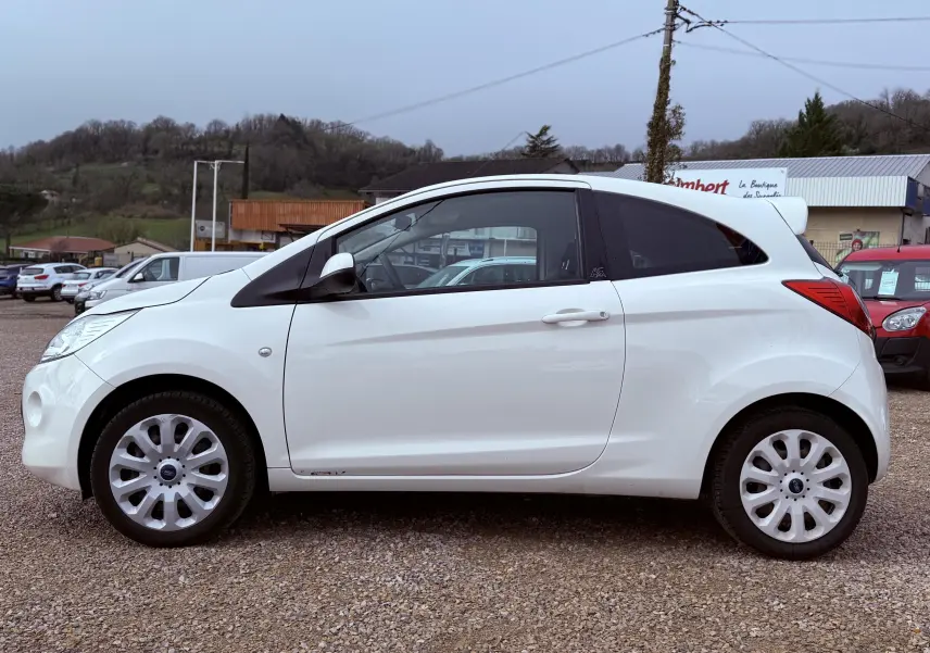 Profil latéral droit d'une Ford KA blanche à 3 portes, avec jantes alliage et vitres teintées.