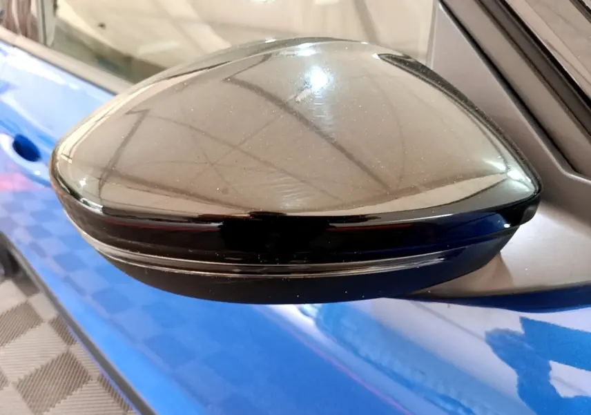 Rétroviseur noir côté gauche de l’Opel Mokka bleu 2024, avec clignotant intégré visible en extérieur.