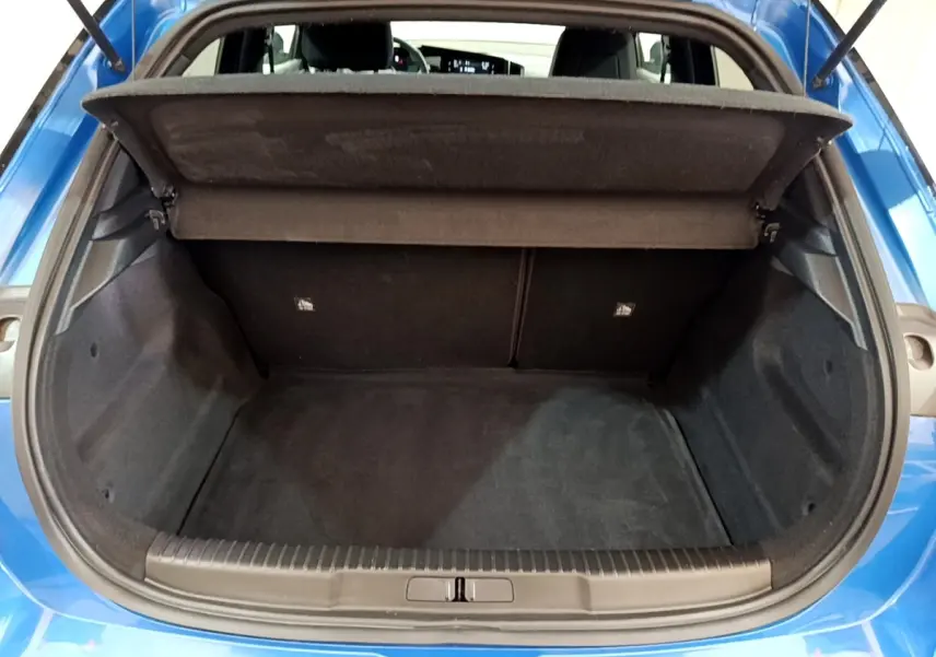 Vue arrière du coffre ouvert d’un Opel Mokka bleu 2024, montrant l’espace de chargement vide et la tablette cache-bagages relevée.