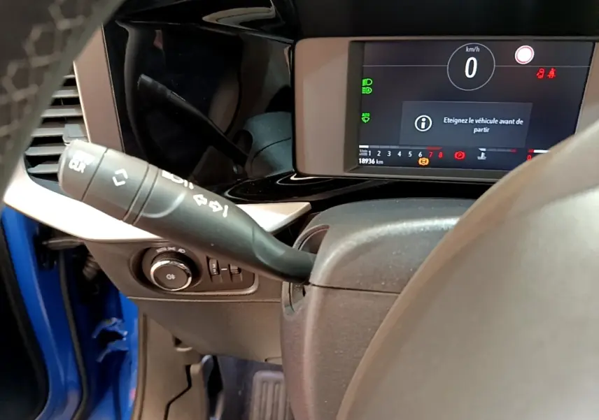 Vue rapprochée du combiné d'instruments numérique et du commodo gauche dans un Opel Mokka bleu 2024.