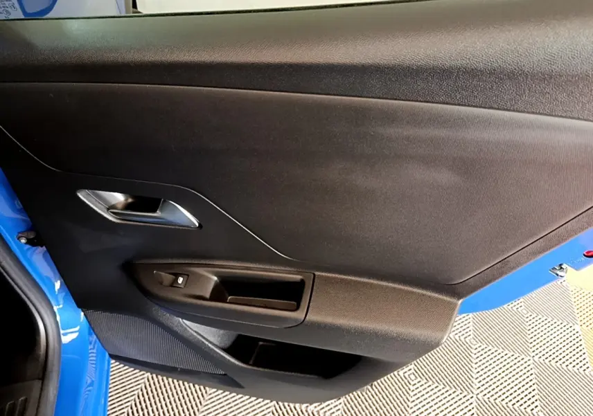 Vue rapprochée de la porte avant gauche bleue de l’Opel Mokka 2024 avec poignée argentée et commande de vitre.
