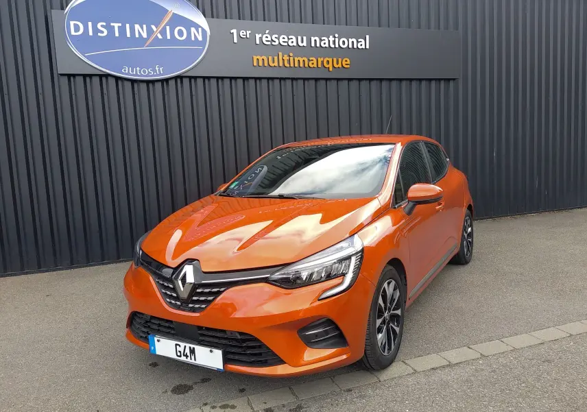 Renault Clio V E-Tech orange en 3/4 avant droit, avec calandre noire et jantes alliage bicolores.