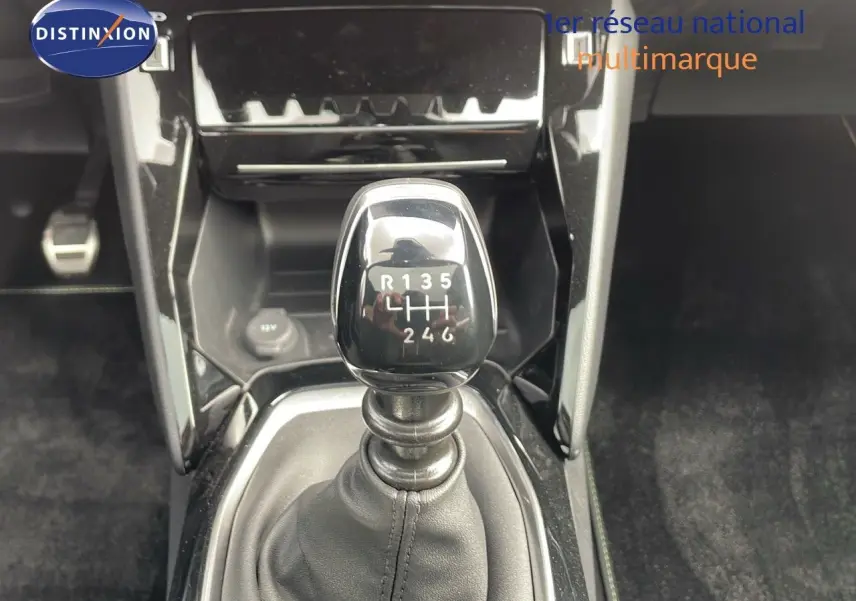 Le levier de vitesse manuel noir brillant de la Peugeot 208 1.2 PureTech GT, vue rapprochée intérieure.