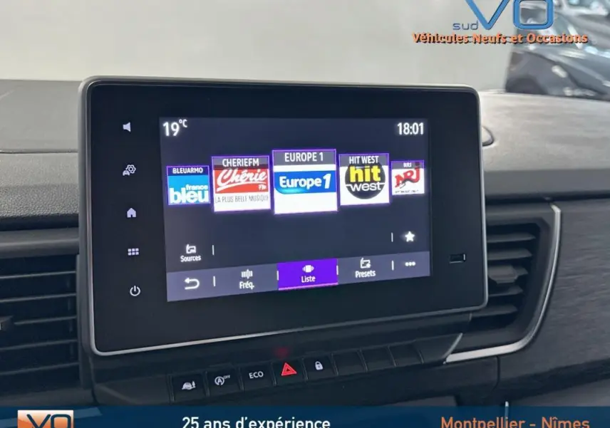 Écran tactile multimédia du Renault Trafic Fourgon gris 2025, affichant les stations radio avec commandes sous l'écran.