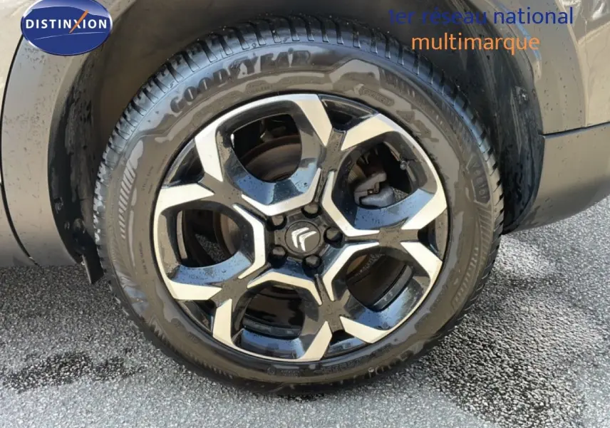 Gros plan sur la jante alliage bicolore noire et argent du côté arrière droit d’un Citroën C5 Aircross gris platinium.