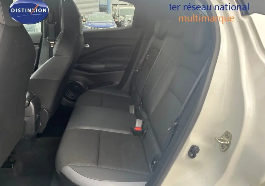 Vue intérieure arrière côté droit du Nissan Juke blanc nacré, montrant les sièges arrière en tissu noir.