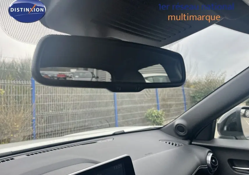 Vue intérieure du tableau de bord et rétroviseur d'une Nissan Juke blanc nacré 2024, côté droit visible.