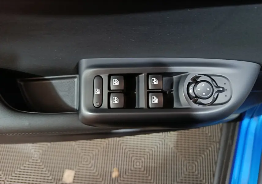 Vue rapprochée des commandes des vitres et rétroviseurs sur la porte côté conducteur d'une Alfa Romeo Tonale bleu.