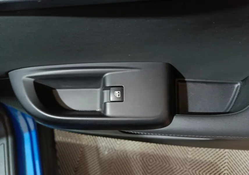 Gros plan sur la commande de lève-vitre côté gauche d'une Alfa Romeo Tonale bleu 2023, intérieur noir.