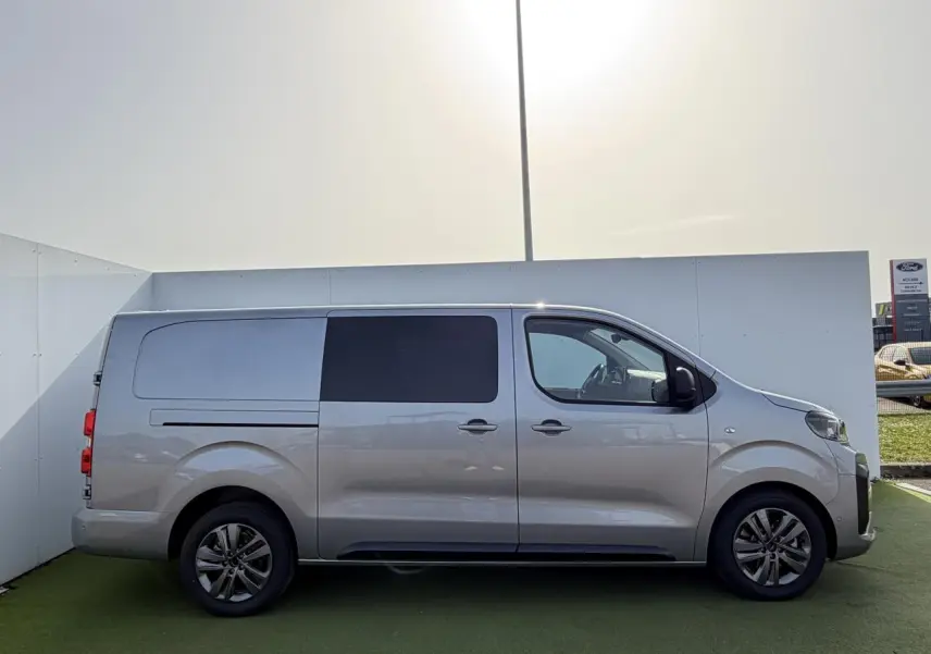 Vue latérale droite d'un Citroën Jumpy gris acier métal avec jantes alliage 17'' et vitres latérales extra-teintées.