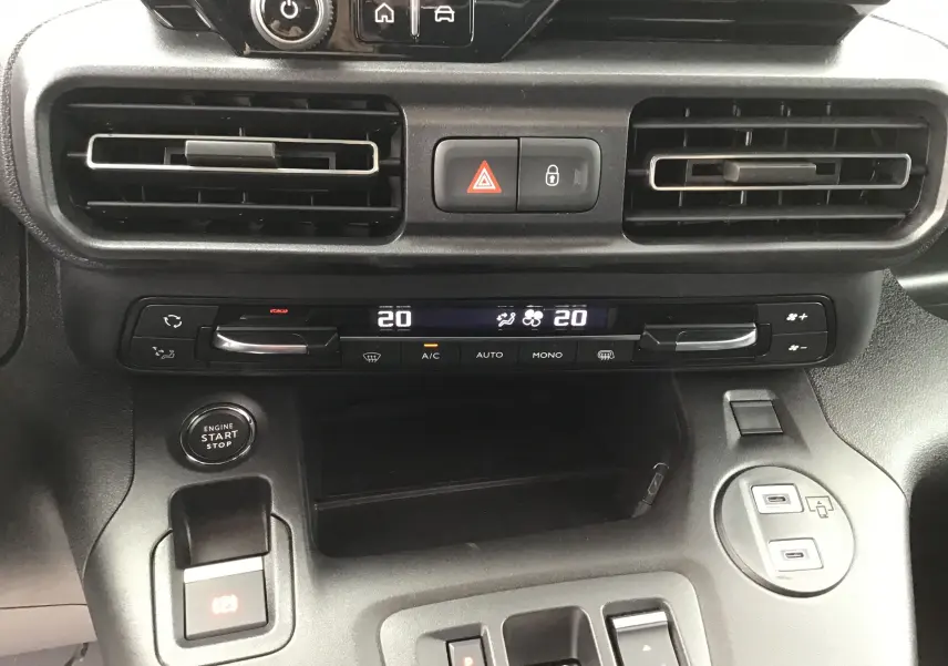 Vue rapprochée du tableau de bord noir du Peugeot Partner 2026, avec commandes climatisation digitale et bouton start/stop.
