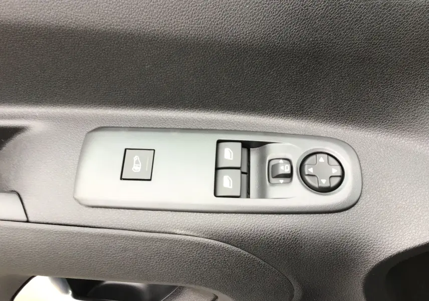 Gros plan sur les commandes des vitres et rétroviseurs côté conducteur du Peugeot Partner blanc 2026.