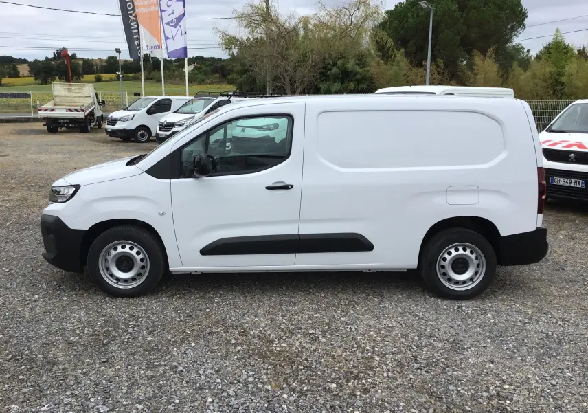 Peugeot Partner blanc en vue de profil côté gauche, utilitaire avec porte latérale coulissante et jantes acier simples.