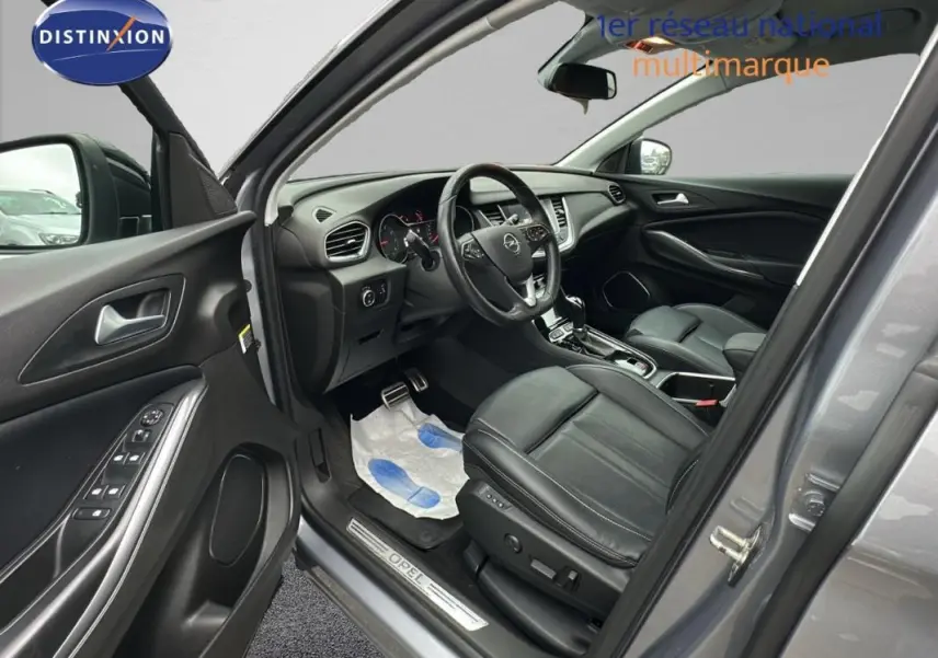 Vue intérieure côté conducteur d'un Opel Grandland X gris clair de 2020 avec sièges cuir noirs et volant multifonctions.