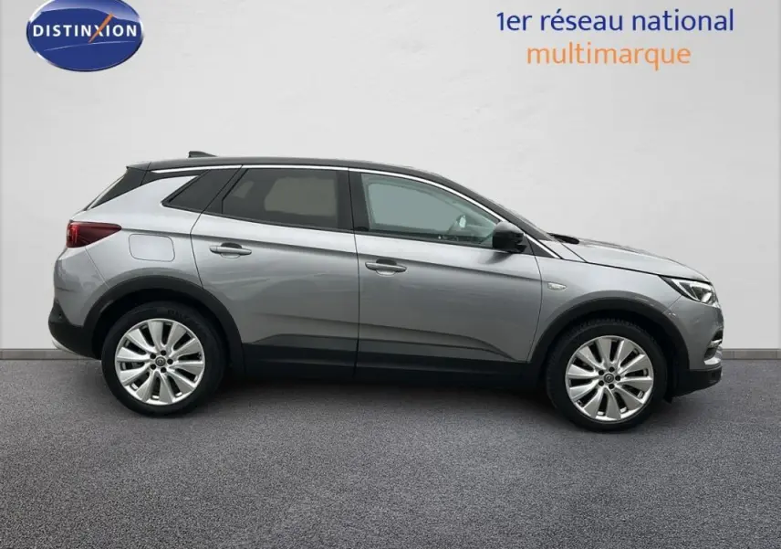 Opel Grandland X gris clair vu de profil côté gauche, avec jantes alliage 19 pouces et lignes épurées.