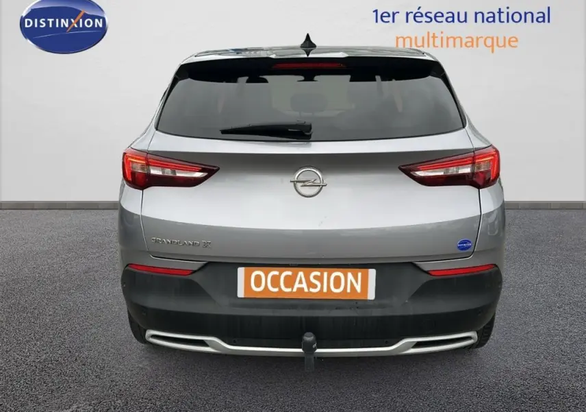 Vue arrière d'un Opel Grandland X gris clair avec attelage et feux arrière LED visibles.