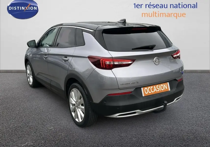 Vue 3/4 arrière droite d'un Opel Grandland X gris clair avec attelage et jantes alliage 19 pouces.